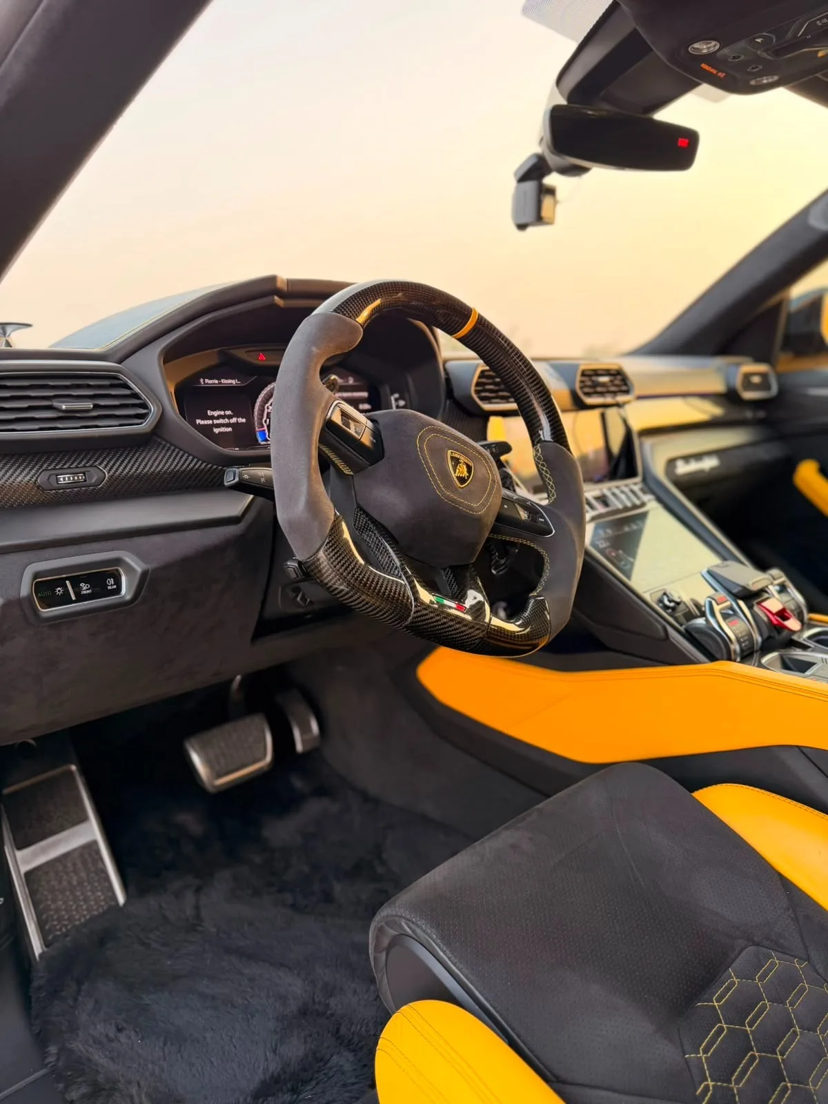 Yellow Urus cockpit with carbon-fibre steering wheel and suede grips