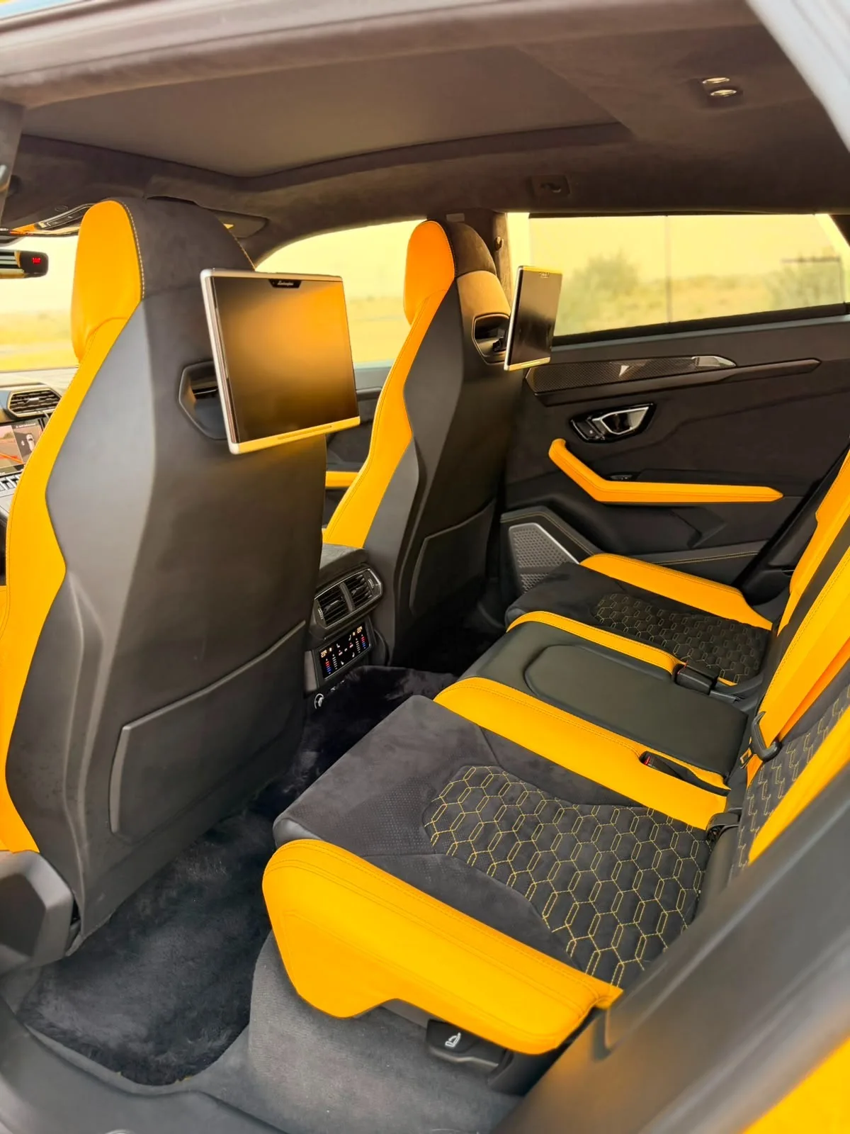 Yellow Urus rear seats with headrest screens and yellow leather